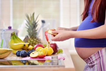 pregnant woman peeling apple