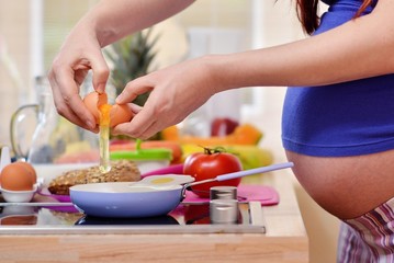 pregnant woman prepares a meal
