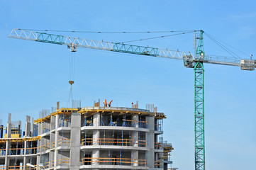 Crane and building construction site against blue sky