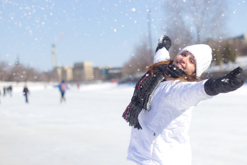 Happy woman playing with the snow during winter