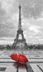 Naklejka premium Wieża Eiffla w deszczu. Czarno-białe zdjęcie z czerwonym elementem