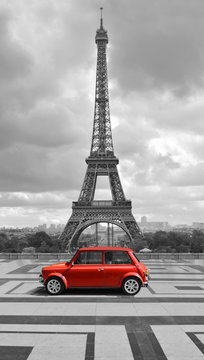 Fototapeta Wieża Eiffla z samochodem. Czarno-białe zdjęcie z czerwonym elementem.