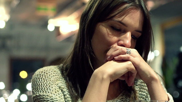 Sad beatiful woman drinking wine in bar late at night