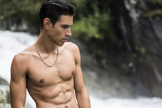 Handsome shirtless young man near mountain waterfall - Powered by Adobe
