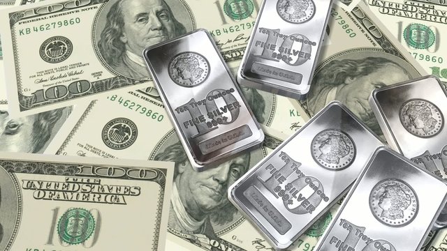 Dolly shot across $100 bills and 10 ounces silver bars