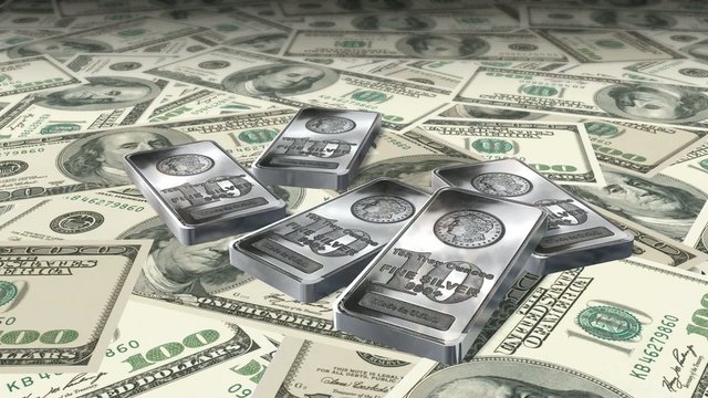Dolly shot across $100 bills and 10 ounces silver bars