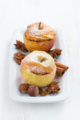baked stuffed apples on a plate on white wooden table