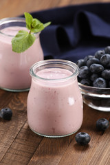 yogurt with blueberries in a glass jar and blueberries in a glas