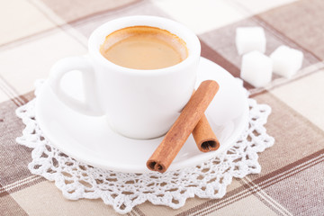 White cup of coffee on tablecloth