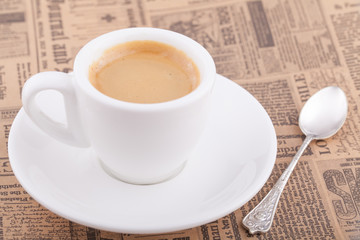 White cup of coffee on newspaper