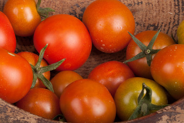 Fototapeta na wymiar freshly picked tomatoes in old dirty wooden plate
