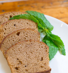 Slices of banana cake on white plate with leaves of mint