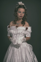 Victorian fashion woman wearing white dress. Studio shot against