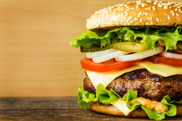Burger in a white plate on wooden table close up
