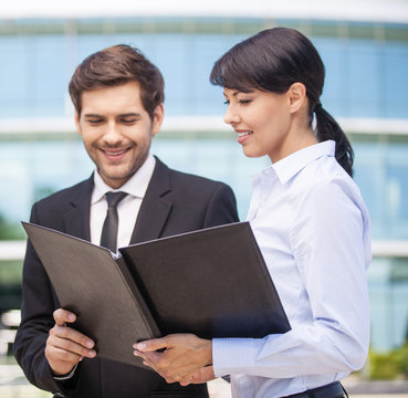 Businessman looking at paperwork with businesswoman.