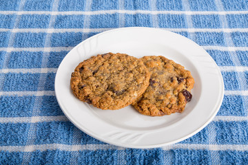 Two Oatmeal Raisin Cookies on White Plate