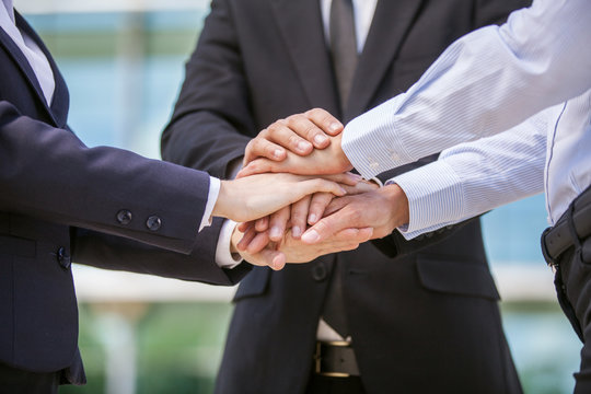 Closeup of business team holding hands together.