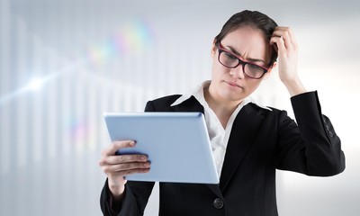 Fototapeta na wymiar Composite image of thinking businesswoman looking at tablet pc