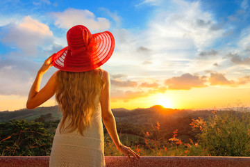 A back side view on a wonderful young woman watching sunset.
