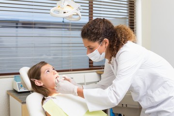 Pediatric dentist examining a patients teeth