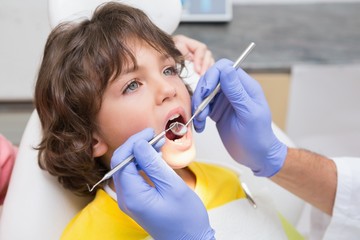Pediatric dentist examining a little boys teeth