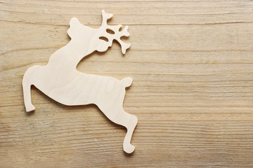 Wooden deer on wooden background, copy space