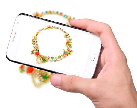 Hands taking photo jewelry with smartphone