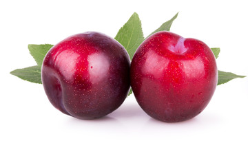 two ripe plums with leaves