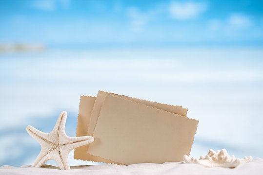 white starfish with blank retro photo on white sand beach, sky a