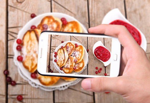 Hands taking photo pancakes with smartphone