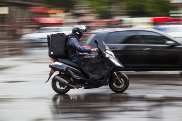 Motorroller auf nasser Fahrbahn