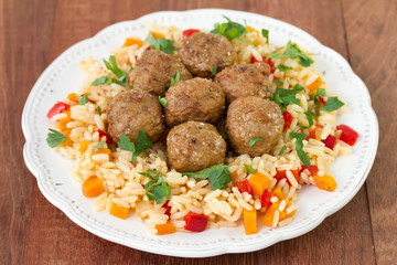 meatballs with rice with vegetables on white plate