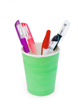 different pens in a green plastic cup