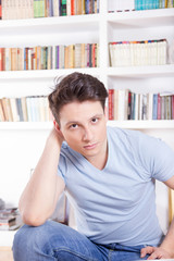 good looking man posing in blue t-shirt and jeans at home