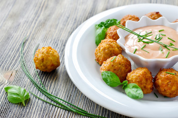 Falafels ready to eat on a plate with sauce and herbs