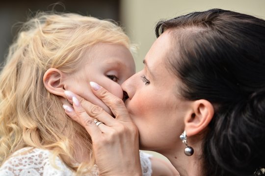 mother kissing her daughter