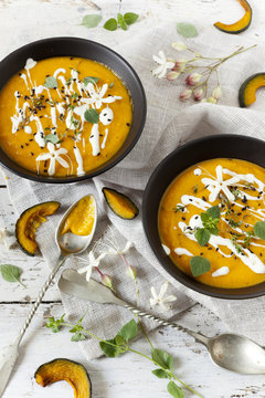 cream of pumpkin and carrot soup on bowls with sour cream
