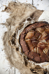 pears and dark chocolate tart on rustic vintage background