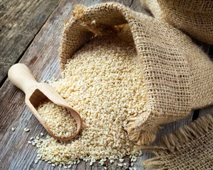 Fotobehang sesame seeds in sack on  rustic table © chamillew
