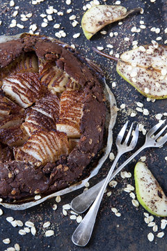homemade pears and dark chocolate tart with oat flakes