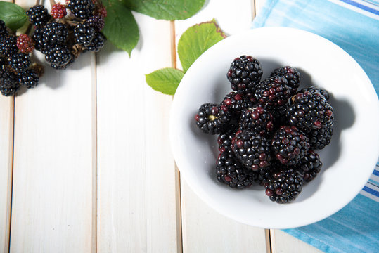 fresh blackberries on plate on kitchen table