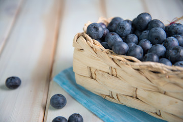 Fresh blueberries in basket on kitchen table