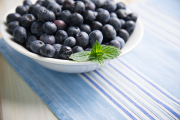 fresh blueberries ion white plate on kitchen table