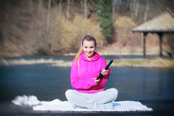 Sport teenage girl using tablet touchpad on pier