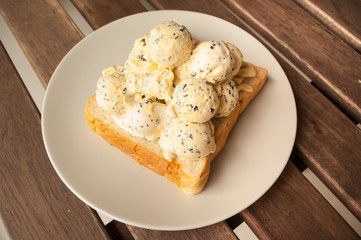 Ice cream on a slice of bread on woodden table