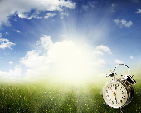 Alarm clock in field. Springtime. Daylight savings