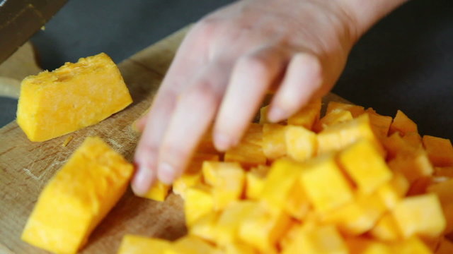 Closeup of hands cutting pumpkin