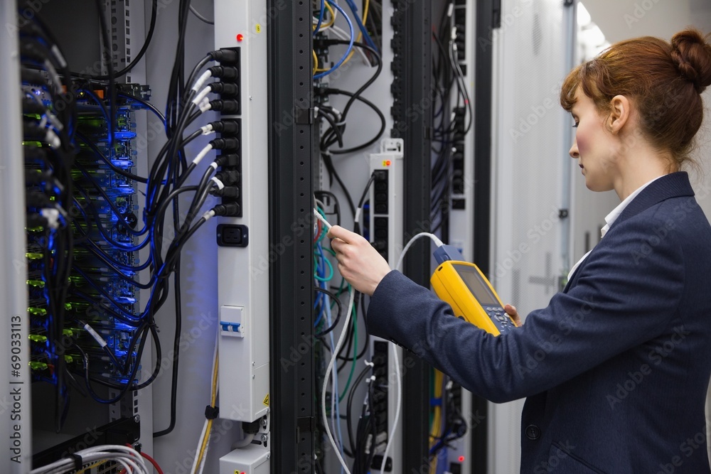 Aufkleber technician using digital cable analyzer on server