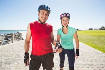 Fototapeta premium Fit mature couple rollerblading on the pier