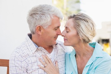 Happy mature couple sitting on bench in the city